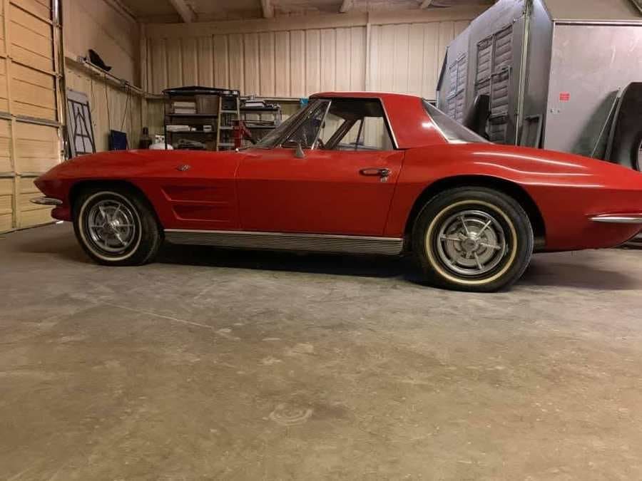 Red early-sixties Corvette convertible parked in the shop